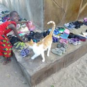 Kleines Maedchen in Kenia sucht sich Schuhe aus